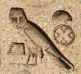 The crocodile scales represent "k", the owl "m", and the bread is "t". The crossroads inform the reader that this is a place. Therefore, it reads "K-m-t". We only get so much in glyphs; the pronunciation "Kemet" is a guess.