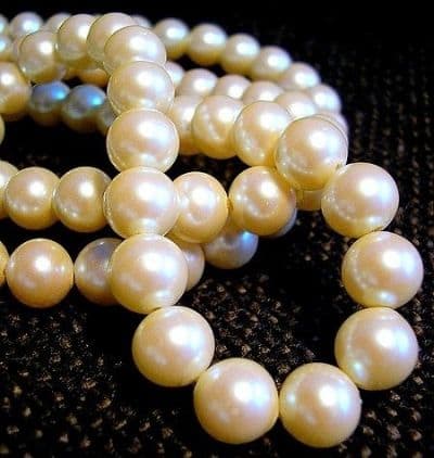 ... and they are more valuable than the pearls in the previous photo because they are well-matched in size, shape, and color. (These are genuine but unstrung and that's probably why they aren't yet knotted.)