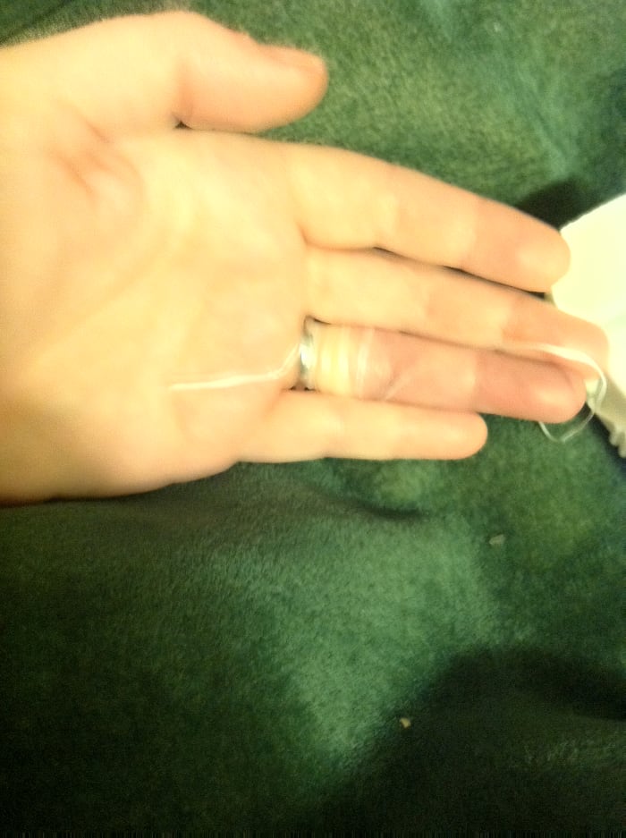 Begin to unwrap by pulling on the part of the string that went under the ring--pull away from your wrist toward the end of your finger