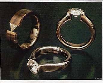 These classic solitaires from Stephen Kretchmer Designs are tension set. Note the absence of a base under the gemstone.