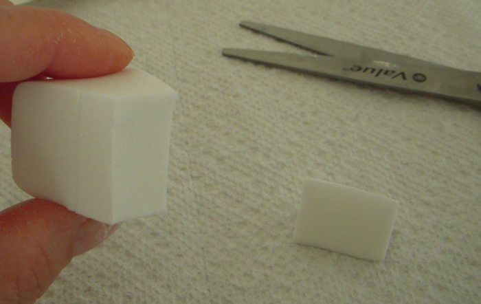 The wedge sponge, cut into two pieces. The large piece (holding) is too wide. You'll want the smaller piece, which is on the paper towel.
