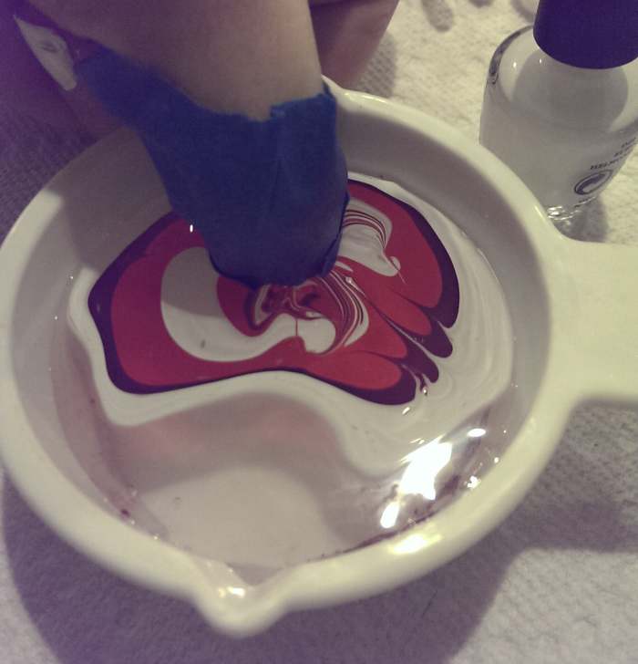 Here, I have dipped my nail into the polish and am holding it in the water. This allows time for the design to bond to my nail. Whatever you do, don't lift your nail back out of the water at this point.