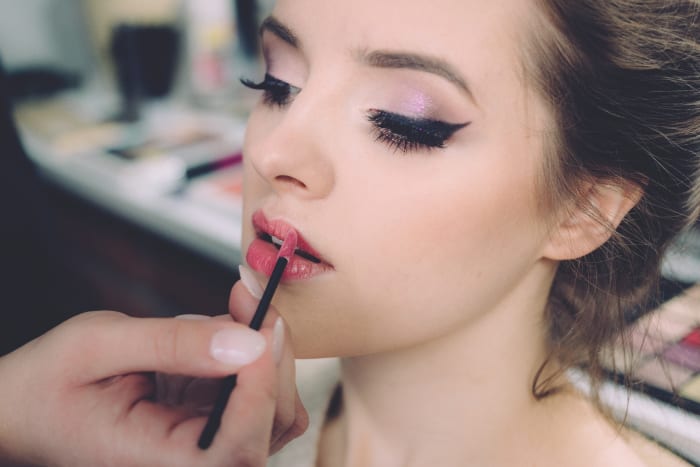 Understated lips, false lashes and thick winged eyeliner.
