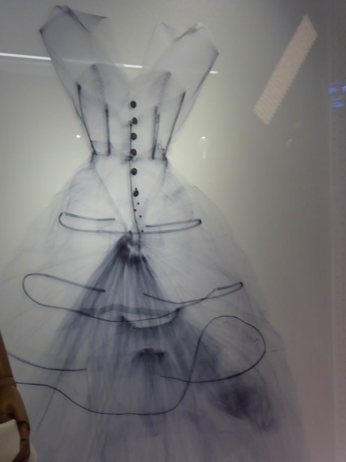 This x-ray of the silk taffeta evening dress is shown next to the garment. It reveals the hoops that maintain the shape and volume of garment. Image by Frances Spiegel with permission from V&A Museum. All rights reserved.