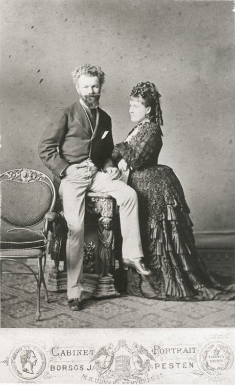 1870s: The flounced high set bustle with train and hanging sausage curls at the back of her head suggest this photo was taken in the 1870s.