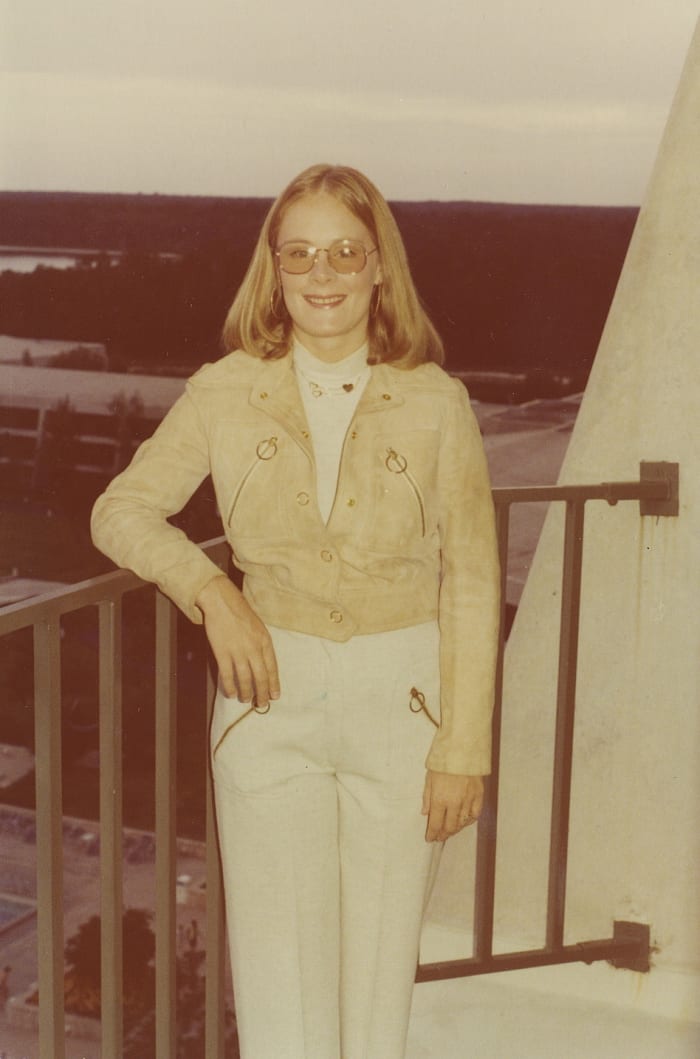 Loose, carefree hair, denim jacket and pants, short waistline, and natural look suggest the 1970s. All you really need to see is the weird yellow tint.