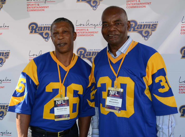 Former Los Angeles Rams running backs, Wendell Tyler (26) and Lawrence McCutcheon (30), pose at an NFL All-Access event at the Los Angeles Memorial Coliseum in 2016.