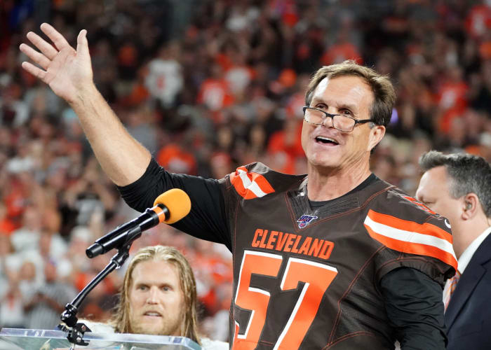 Former Cleveland Browns linebacker, Clay Matthews Jr. (57), speaks as he is inducted into the Browns Ring of Honor at halftime of a 2019 game against the Los Angeles Rams. His son and Rams linebacker, Clay Matthews III, can be seen in the background.