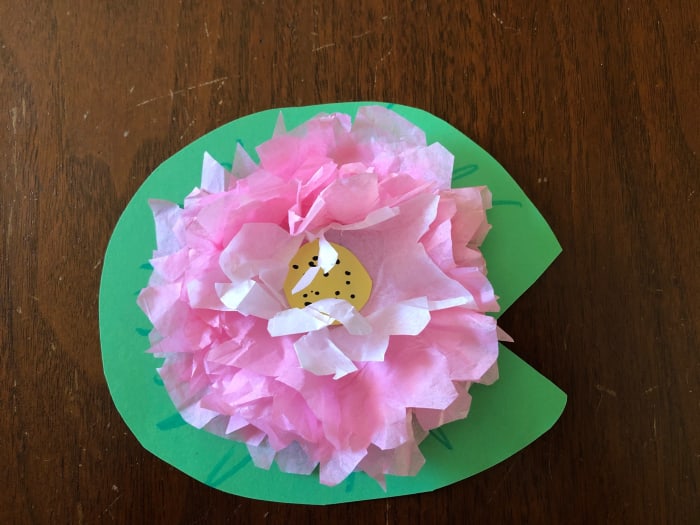 Glue the first piece of tissue paper to the construction paper, then continue gluing each additional piece on top of the previous piece. Glue a small circle of yellow construction paper in the center and fluff the petals.
