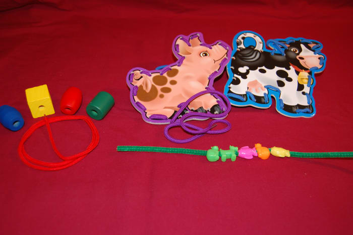String beads on string or pipe cleaner with straightening movement of fingers, or lace in vertical position.
