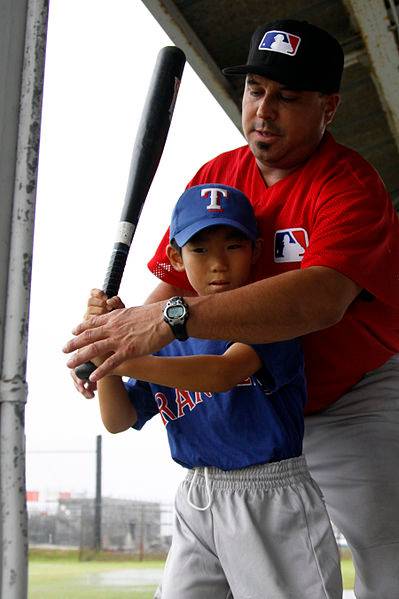 A coach working with a Little League player