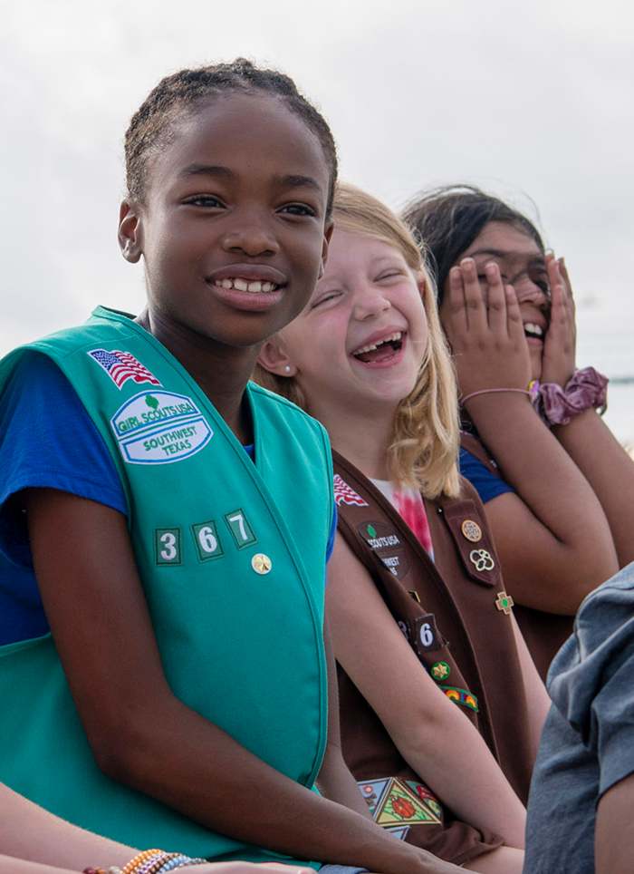You can see the American flag, council emblem, troop numbers, and membership star on the right side of this Junior's vest. The Brownie beside her has these patches placed the same way, plus the felt tab on the left side of her vest.