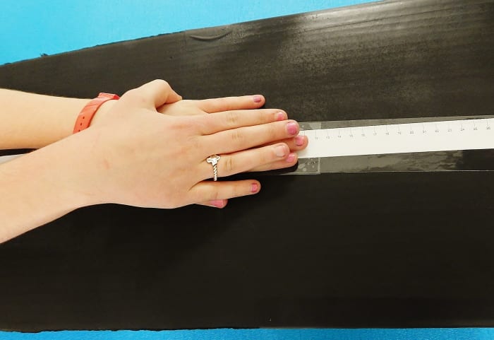 Participants need to put one hand on the other and reach forward as far as they can without bouncing.