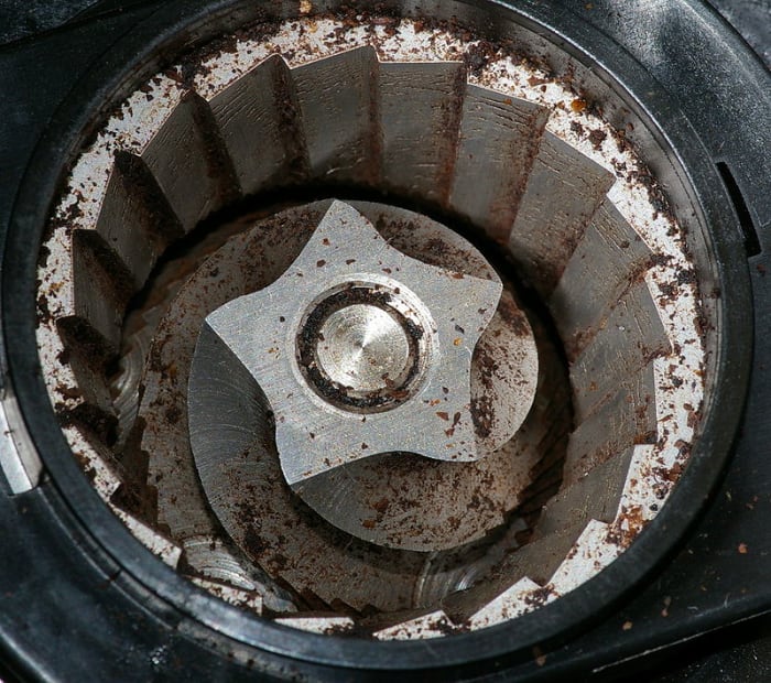 A burr grinder interior. The bean hopper, which sits on top, has been removed in order to see inside. The coffee beans are crushed and torn, rather than chopped, meaning that very little heat is generated.