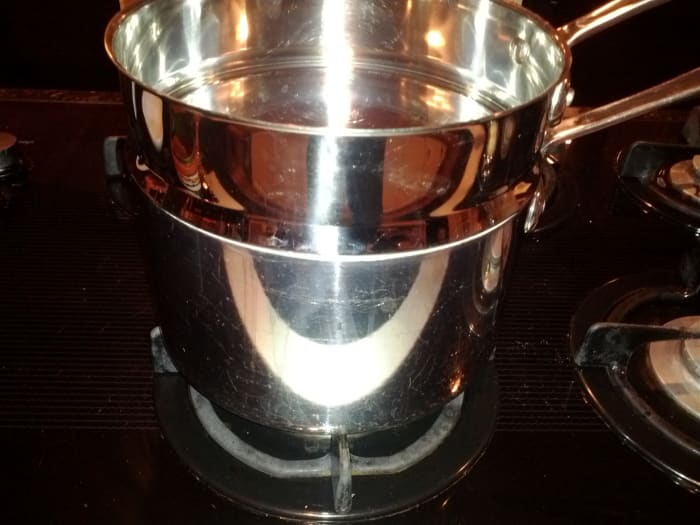 A double boiler has a pot on the bottom with the boiling water and a pot on top to hold the ingredients. The point of the double boiler is to avoid direct heat.