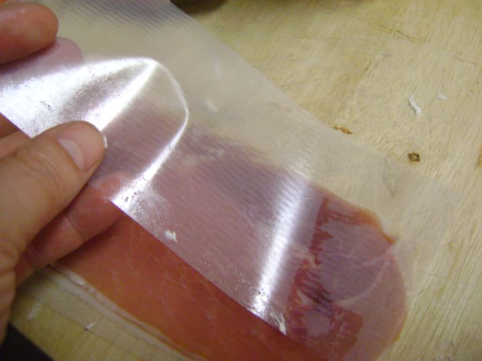 I find it helpful to keep the prosciutto slice on the wax paper separator. This gives the meat something to grip onto as you spread the cream cheese.