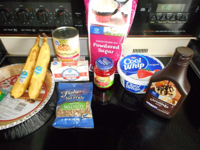 From left to right: 9' graham cracker crust, bananas, walnuts, cream cheese, pineapple, cherries, powdered sugar, Cool Whip and chocolate syrup