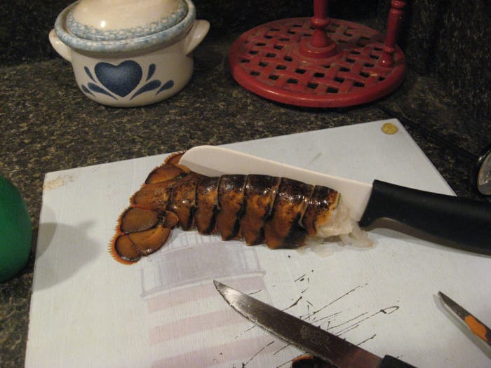 To butterfly the lobster, place a knife blade into the cut you made. Rock it back and forth, cutting through the meat. Do not cut into the belly shell. Remove the intestine, and discard it.