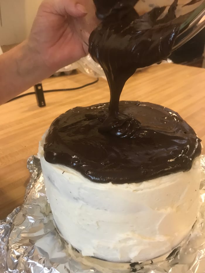 The ganache will pour easily if you use it immediately. Here it is poured over a black velvet cake frosted with simple buttercream.