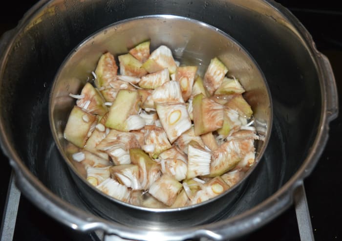 Step two: Strain the water. Put them in a cooker container. Add washed split pigeon pea. Also, add some water and salt. Mix well. Pressure cook them as per instructions.