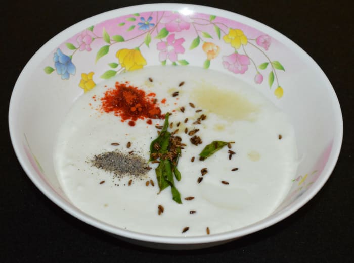 Step one: Put curd or yogurt in a mixing bowl. Add tempering to it, as per instructions. Throw in red chili powder, pepper powder, salt, and sugar. Mix well.