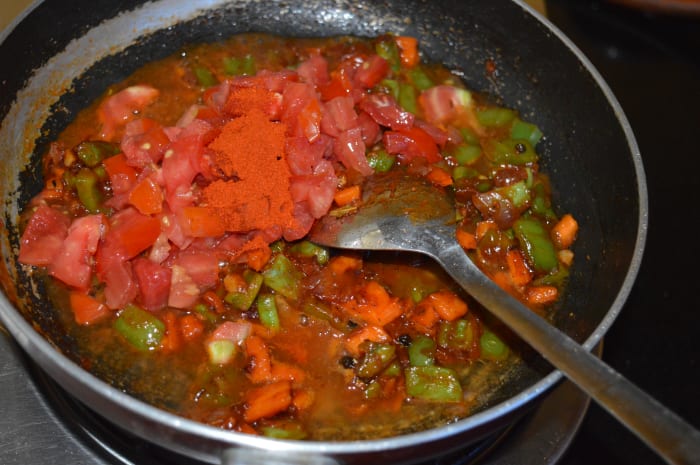 Step five: Add red chili powder, spice powder of your choice, or a spicy sauce, and chopped tomatoes. Cook until tomatoes are soft. Add remaining salt. Mix well.