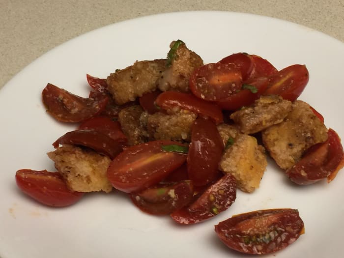 Panzanella Salad made with Parmesan dusted bread cubes fried in olive oil, with mixed cherry tomatoes