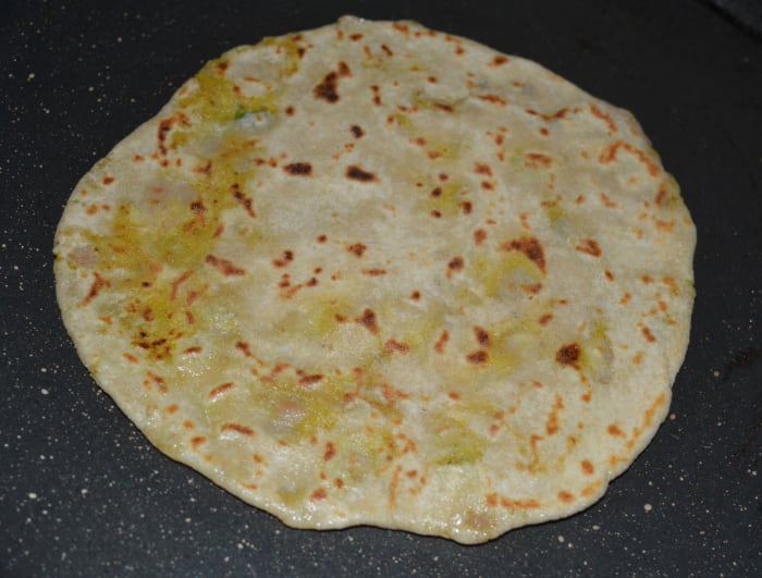 Step seven: Remove it and place on a serving plate. Repeat the same procedure to make all the parathas.