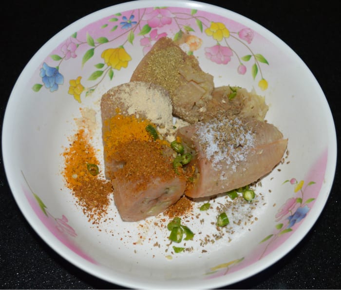 Step three: Take it in a mixing bowl. Add salt, chopped green chilies, chopped coriander, coriander powder, turmeric powder, garam masala powder, carom seeds, and sugar.