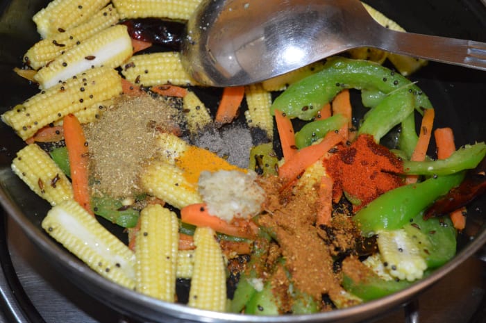 Step three: Add all the spices, sugar, and salt as per instructions. Saute for a few seconds. Add some water and mix well.