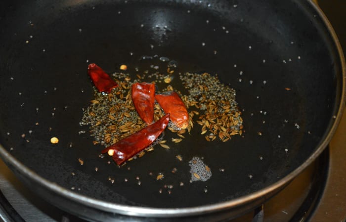 Step one: Heat oil in a deep-bottomed pan. Throw in mustard seeds and cumin seeds. Let them crackle and pop up. Add broken dry red chilies. Saute for 1-2 seconds.