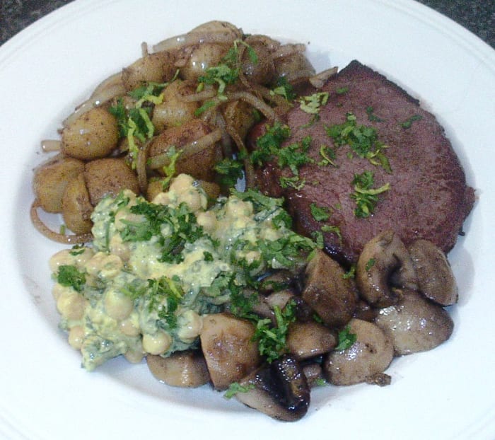 Steak is fried with potatoes and onions fried in its juices, garlic mushrooms and a spicy chickpeas salad