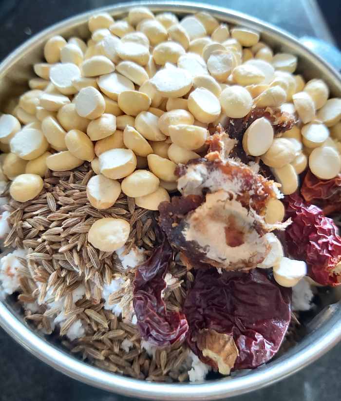 Add 2 teaspoons of cumin seeds, 1 teaspoon of tamarind pulp, 2-3 tablespoons of fried gram and 4-5 byadagi (Kashmiri red chilies).