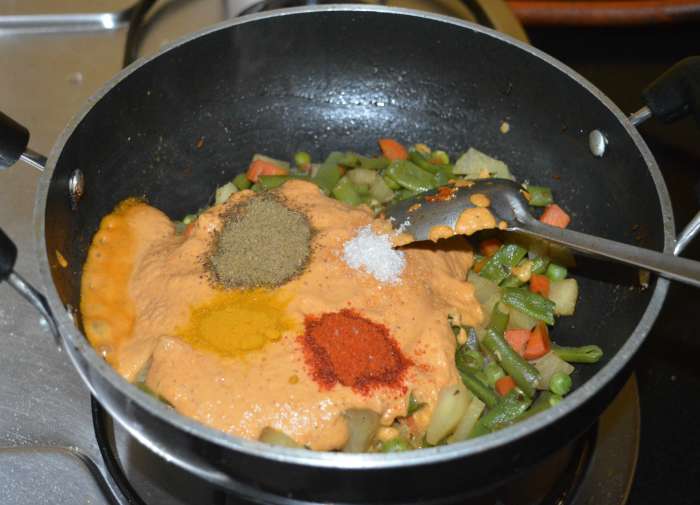 Add red chili powder, garam masala powder, turmeric powder, sugar, and remaining salt. Mix well. Add water if needed to get the right consistency.