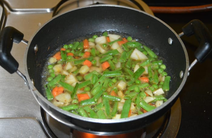 Add 2 cups of water. Cover the pan and simmer until the veggies become soft. This process may take about 3-4 minutes.