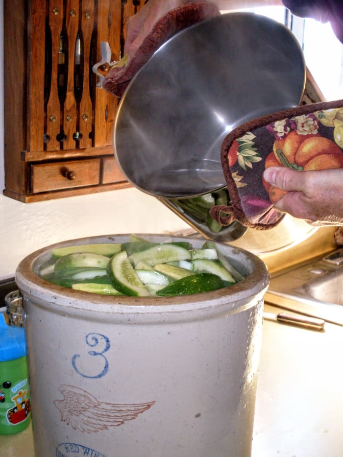 Pour boiling water over cucumber sticks to cover completely. This crock will soak enough pickle sticks for about seven quarts.