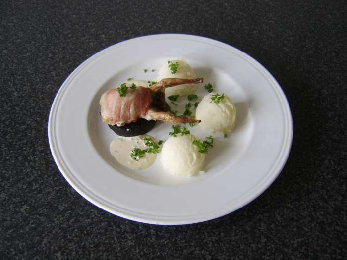 The quail is wrapped in bacon and roasted before being served on a slice of Stornoway black pudding with mashed potatoes and peppercorn cream sauce