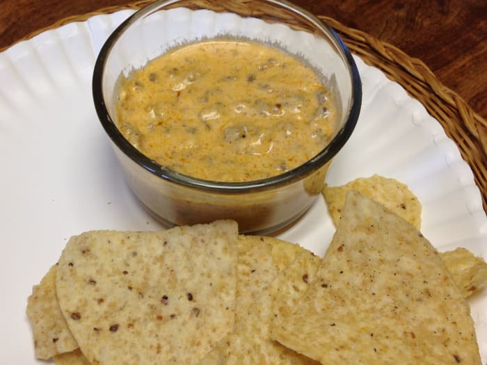 Salsa de queso caliente hecha con queso crema y una variedad de quesos duros, así como cerveza Corona y carne de taco.