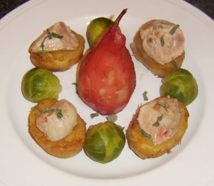 Pan fried partridge breasts are halved and served on fondant potatoes with a pear poached in cranberry juice centrepiece