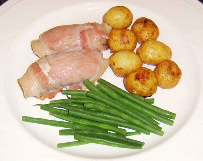 Partridge breast fillets wrapped in bacon and baked, served with roasted potatoes and trimmed green beans