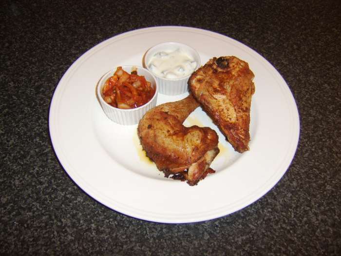 Dry marinated tandoori chicken is roasted and served with spiced onions and yoghurt based Indian raita