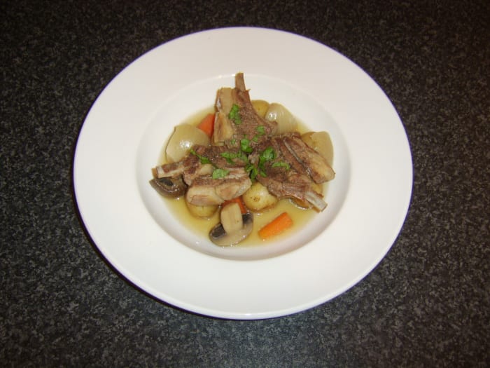 Casseroled lamb chops are laid on top of the root vegetables and garnished with freshly chopped mint