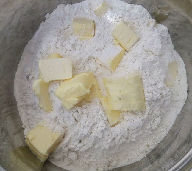 primeiro passo: adicionar manteiga em fatias à farinha.