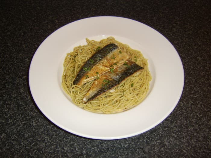 Spaghetti is cooked as normal before being stirred with green pesto sauce and topped with quickly fried mackerel fillets