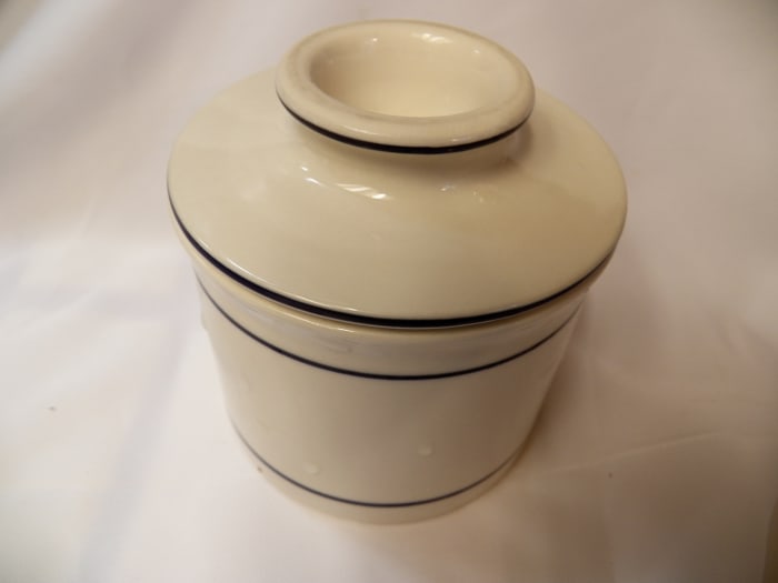 Bell-shaped lid holds butter, while bottom holds water. Putting lid down into water keeps butter fresh and soft at room temperature.