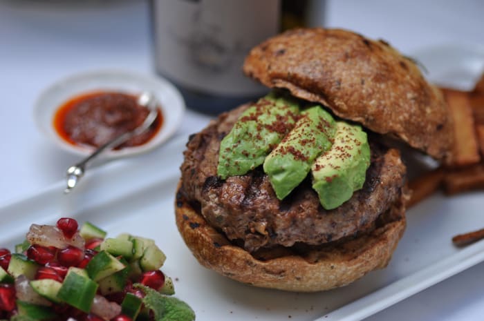 Sumac Lamb Burger on Rosemary Buns. Accompanied with pomegranate, cucumber, lemon and mint salad; home made chips; and harissa. Image: © Siu Ling Hui