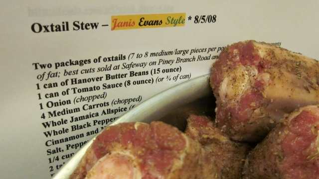 A bowl of seasoned oxtails sits beside my recipe I've been sharing with friends since 2008.