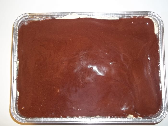 Cake covered with melted frosting. Ready to go in the refrigerator for one hour before serving.