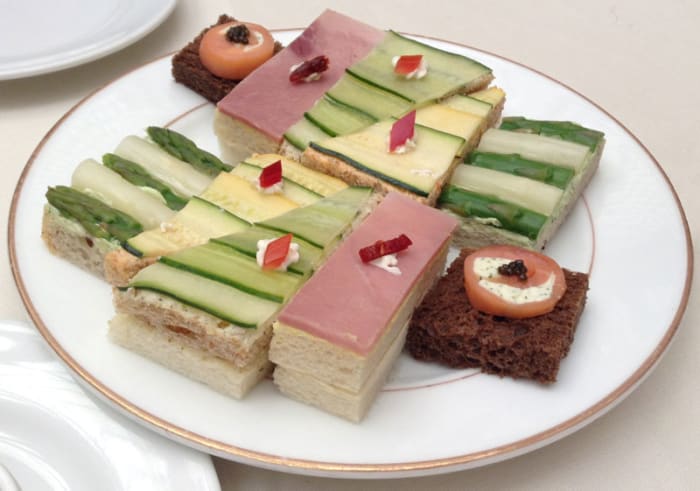 A plate of elegant, stacked, open-face tea sandwiches from the Palace Hotel