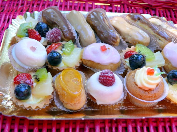 A silver tray of elegant petit fours and miniature tarts, eclairs and puddings